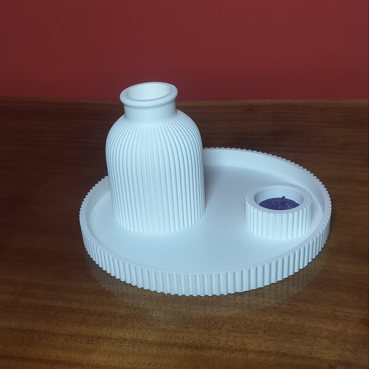 A white ribbed plastic bottle stopper with a small purple accent ring, resting on a wooden table against a red wall.